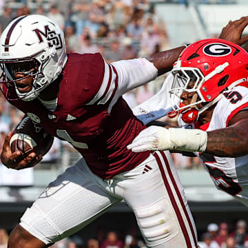 Mississippi State Bulldogs quarterback Kamario Taylor (1) runs with the ball against Georgia Bulldogs linebacker Raylen Wilson (5) during the second half at Davis Wade Stadium at Scott Field.