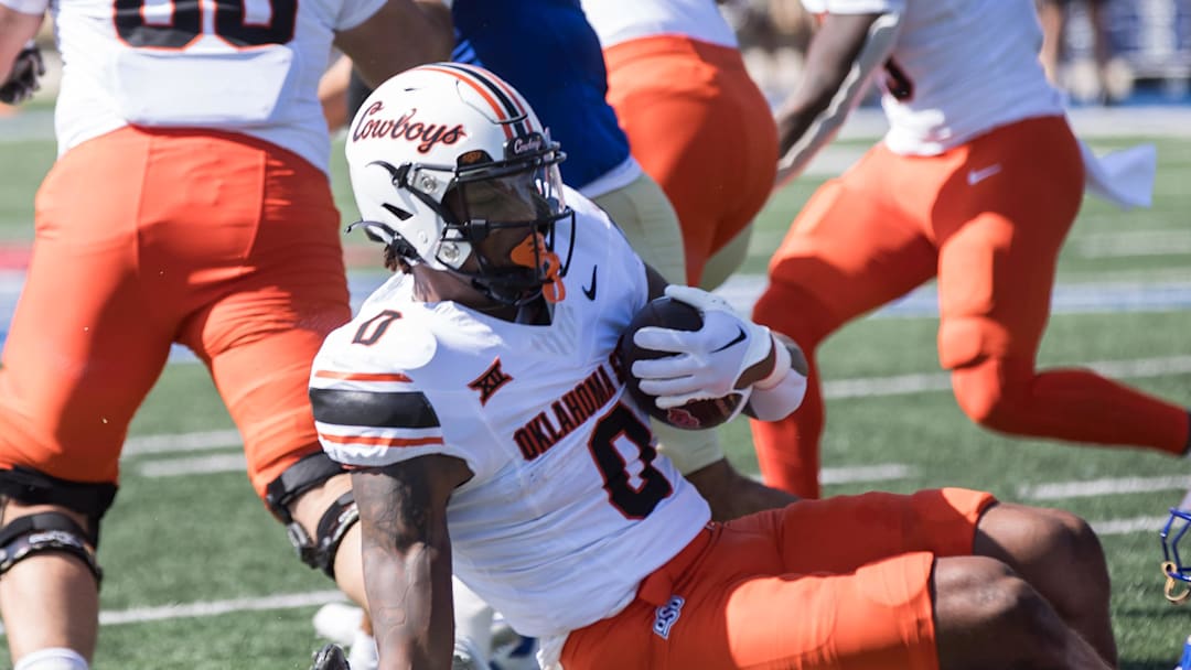 Sep 14, 2024; Tulsa, Oklahoma, USA;  Tulsa Golden Hurricane safety Devin Robinson (16) tackles Oklahoma State Cowboys running back Ollie Gordon II (0) during a game at Skelly Field at H.A. Chapman Stadium. Mandatory Credit: Brett Rojo-Imagn Images