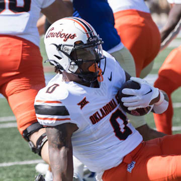 Sep 14, 2024; Tulsa, Oklahoma, USA;  Tulsa Golden Hurricane safety Devin Robinson (16) tackles Oklahoma State Cowboys running back Ollie Gordon II (0) during a game at Skelly Field at H.A. Chapman Stadium. Mandatory Credit: Brett Rojo-Imagn Images