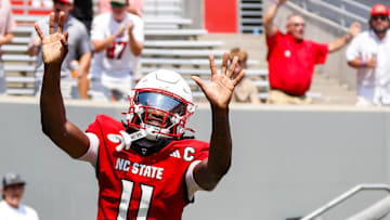 Sep 6, 2025; Raleigh, North Carolina, USA; North Carolina State Wolfpack quarterback CJ Bailey (11) celebrates a touchdown with fans during the first half of the game against Virginia Cavaliers at Carter-Finley Stadium. Mandatory Credit: Jaylynn Nash-Imagn Images