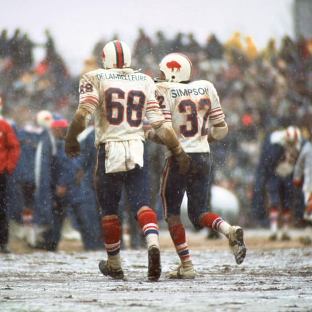 Former Buffalo Bills guard Joe Delamielleure walks off the field with running back O.J. Simpson.