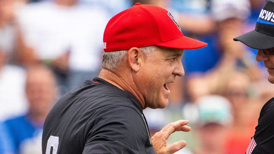 Jun 15, 2024; Omaha, NE, USA; NC State Wolfpack head coach Elliott Avent talks with an official during the seventh inning against the Kentucky Wildcats at Charles Schwab Field Omaha. Mandatory Credit: Dylan Widger-Imagn Images