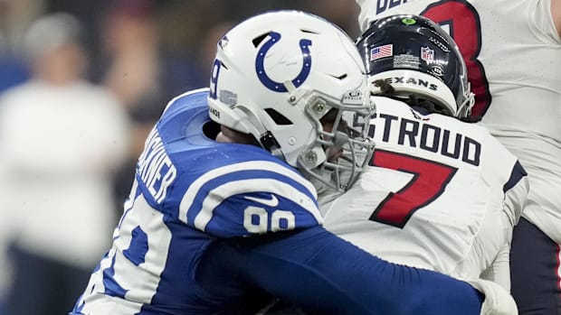 Colts defensive tackle DeForest Buckner (blue jersey; white helmet) tackles an opposing quarterback. 