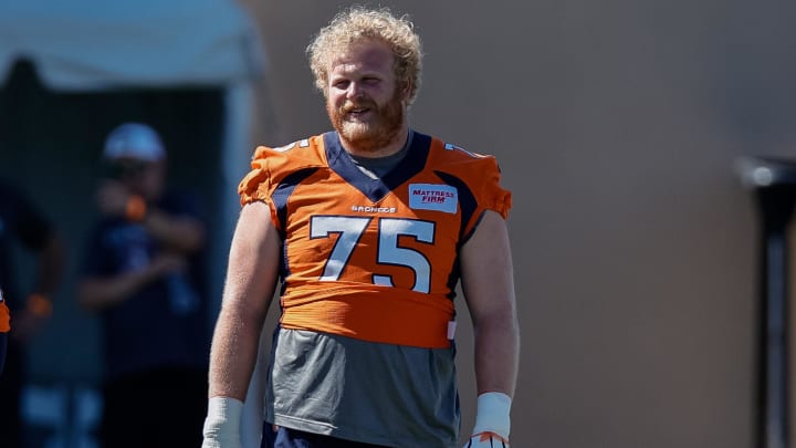 Aug 10, 2022; Englewood, CO, USA; Denver Broncos tackle Quinn Bailey (75) talks with tackle Casey Tucker (74) during training camp at the UCHealth Training Center. 