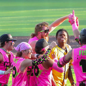 The Party Animals surround Heisman trophy winner Travis Hunter after he tossed out the first pitch during the Savannah Bananas game on Friday, April 11, 2025 at Historic Grayson Stadium.