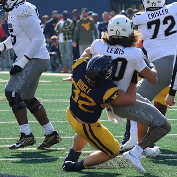 West Virginia University linebacker Ben Bogle sacks Colorado quarterback Julian Lewis. 
