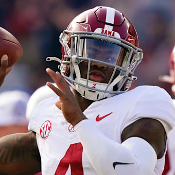 Nov 25, 2023; Auburn, Alabama, USA; Alabama Crimson Tide quarterback Jalen Milroe (4) runs through passing drills during pregame warmups before their game against the Auburn Tigers at Jordan-Hare Stadium. Mandatory Credit: John David Mercer-Imagn Images