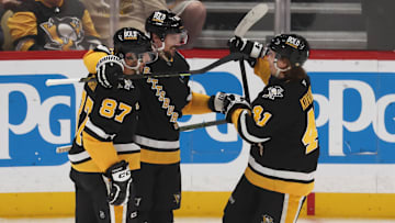 Apr 8, 2025; Pittsburgh, Pennsylvania, USA;  Pittsburgh Penguins center Sidney Crosby (87) and right wing Ville Koivunen (41) congratulate defenseman Erik Karlsson (65) on his 200th career NHL goal against the Chicago Blackhawks during the second period at PPG Paints Arena. Mandatory Credit: Charles LeClaire-Imagn Images