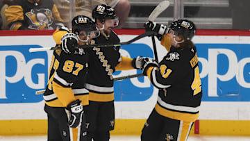 Apr 8, 2025; Pittsburgh, Pennsylvania, USA;  Pittsburgh Penguins center Sidney Crosby (87) and right wing Ville Koivunen (41) congratulate defenseman Erik Karlsson (65) on his 200th career NHL goal against the Chicago Blackhawks during the second period at PPG Paints Arena. Mandatory Credit: Charles LeClaire-Imagn Images