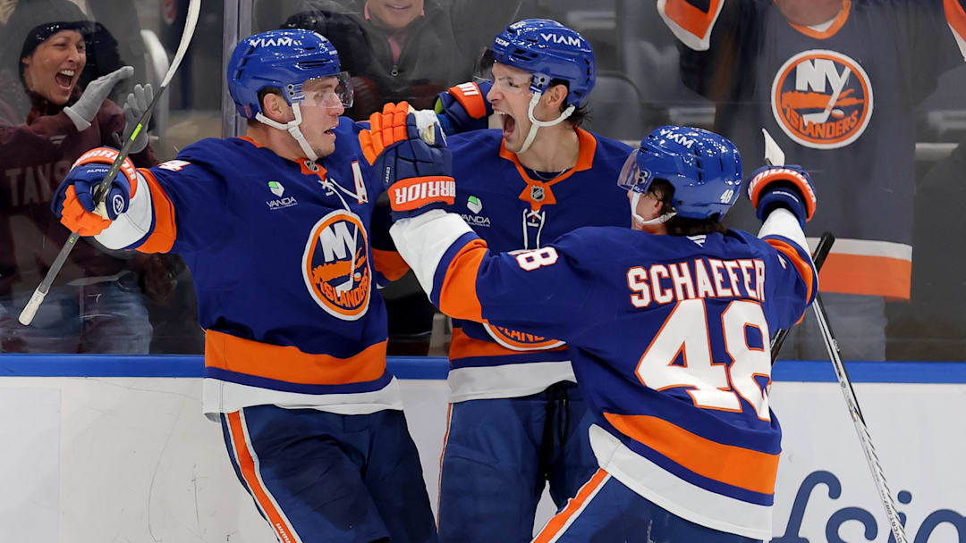 Feb 3, 2026; Elmont, New York, USA; New York Islanders center Bo Horvat (14) celebrates his game winning overtime goal against the Pittsburgh Penguins with center Mathew Barzal (13) and defenseman Matthew Schaefer (48) at UBS Arena. Mandatory Credit: Brad Penner-Imagn Images