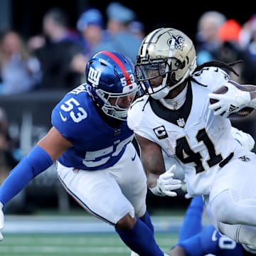 Dec 8, 2024; East Rutherford, New Jersey, USA; New Orleans Saints running back Alvin Kamara (41) runs with the ball against New York Giants linebacker Darius Muasau (53) during the second quarter at MetLife Stadium. Mandatory Credit: Brad Penner-Imagn Images