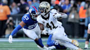 Dec 8, 2024; East Rutherford, New Jersey, USA; New Orleans Saints running back Alvin Kamara (41) runs with the ball against New York Giants linebacker Darius Muasau (53) during the second quarter at MetLife Stadium. Mandatory Credit: Brad Penner-Imagn Images