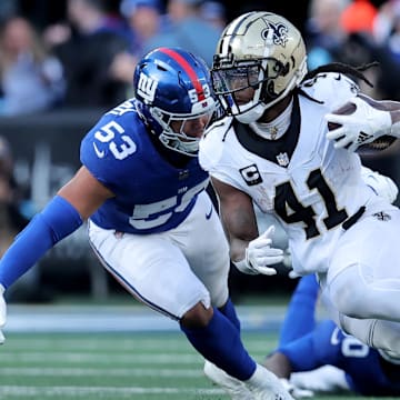 Dec 8, 2024; East Rutherford, New Jersey, USA; New Orleans Saints running back Alvin Kamara (41) runs with the ball against New York Giants linebacker Darius Muasau (53) during the second quarter at MetLife Stadium. Mandatory Credit: Brad Penner-Imagn Images