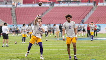 Jan 1, 2024; Tampa, FL, USA; LSU Tigers quarterbacks Garrett Nussmeier (13) and Rickie Collins (10) participate in drills before the game against the Wisconsin Badgers at Raymond James Stadium. Mandatory Credit: Matt Pendleton-Imagn Images