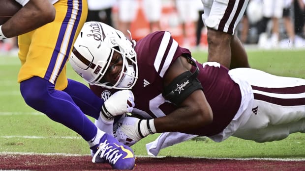 LSU Tigers quarterback Jayden Daniels runs for a touchdown while defended by Mississippi State Bulldogs safety Isaac Smith.