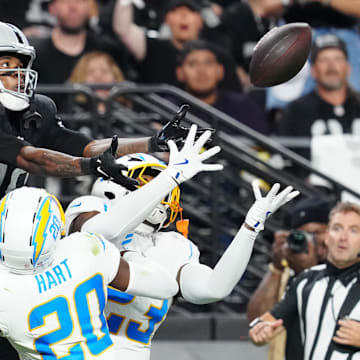 Sep 15, 2025; Paradise, Nevada, USA; Las Vegas Raiders wide receiver Dont'e Thornton Jr. (10) attempts to make a catch as Los Angeles Chargers cornerback Cam Hart (20) and Los Angeles Chargers safety Tony Jefferson (23) defend during the second quarter at Allegiant Stadium. Mandatory Credit: Stephen R. Sylvanie-Imagn Images