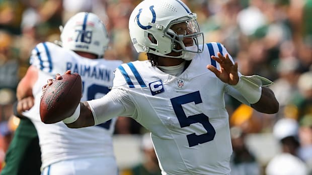 Colts quarterback Anthony Richardson (all-white uniform) gets ready to throw a pass down the field to an open receiver.