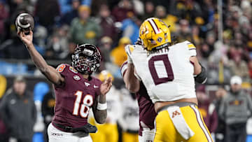 Jan 3, 2025; Charlotte, NC, USA; Virginia Tech Hokies quarterback William Watson III (18) makes a throw over Minnesota Golden Gophers defensive lineman Anthony Smith (0) during the second half at the Duke’s Mayo Bowl at Bank of America Stadium. Mandatory Credit: Jim Dedmon-Imagn Images