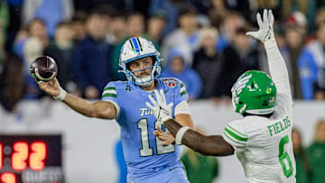 Tulane quarterback Jake Retzlaff passes around North Texas linebacker Trey Fields during the first half in the American championship game on Friday.