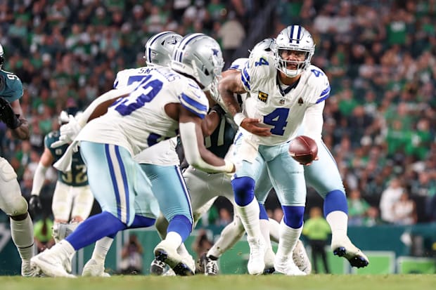 Dallas Cowboys quarterback Dak Prescott hands the ball to running back Javonte Williams. 