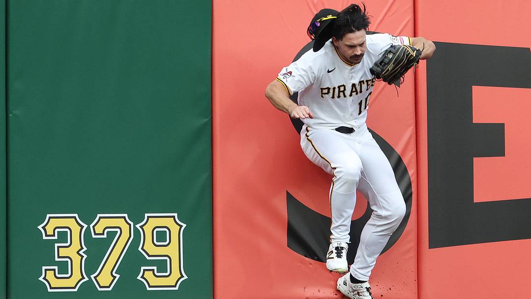Jun 11, 2026; Pittsburgh, Pennsylvania, USA;  Pittsburgh Pirates left fielder Bryan Reynolds (10) crashes into the wall after robbing Los Angeles Dodgers shortstop Mookie Betts (not pictured) of a home run during the third inning at PNC Park. Mandatory Credit: Charles LeClaire-Imagn Images