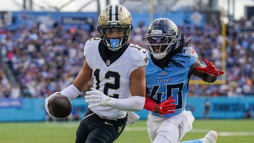 Dec 28, 2025; Nashville, Tennessee, USA; New Orleans Saints wide receiver Chris Olave (12) runs in a touchdown in front of Tennessee Titans cornerback Kemon Hall (40) during the third quarter  at Nissan Stadium. Mandatory Credit: Andrew Nelles-USA TODAY Network via Imagn Images
