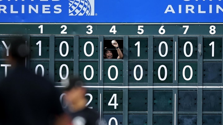 A manual scoreboard operator holds up a ball hit by Astros second baseman Jose Altuve against the Chicago White Sox at Minute Maid Park.