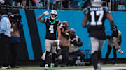 Nov 30, 2025; Charlotte, North Carolina, USA; Carolina Panthers wide receiver Tetairoa McMillan (4) celebrates after scoring a touchdown during the fourth quarter against the Los Angeles Rams at Bank of America Stadium.