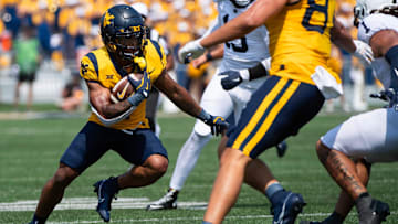 West Virginia running back Jahiem White carries the ball in the first half of an NCAA football game against Penn State, Saturday, August 31, 2024, in Morgantown, W. Va.