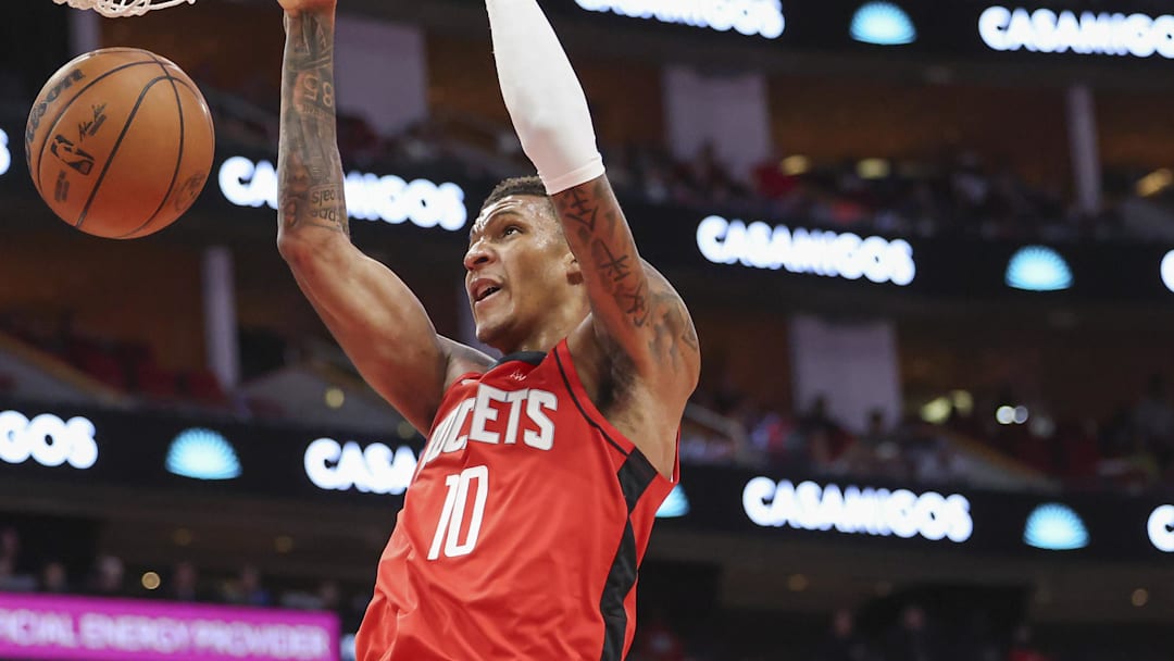 Jan 1, 2025; Houston, Texas, USA; Houston Rockets forward Jabari Smith Jr. (10) dunks the ball as Dallas Mavericks guard Kyrie Irving (11) defends during the first quarter at Toyota Center. Mandatory Credit: Troy Taormina-Imagn Images