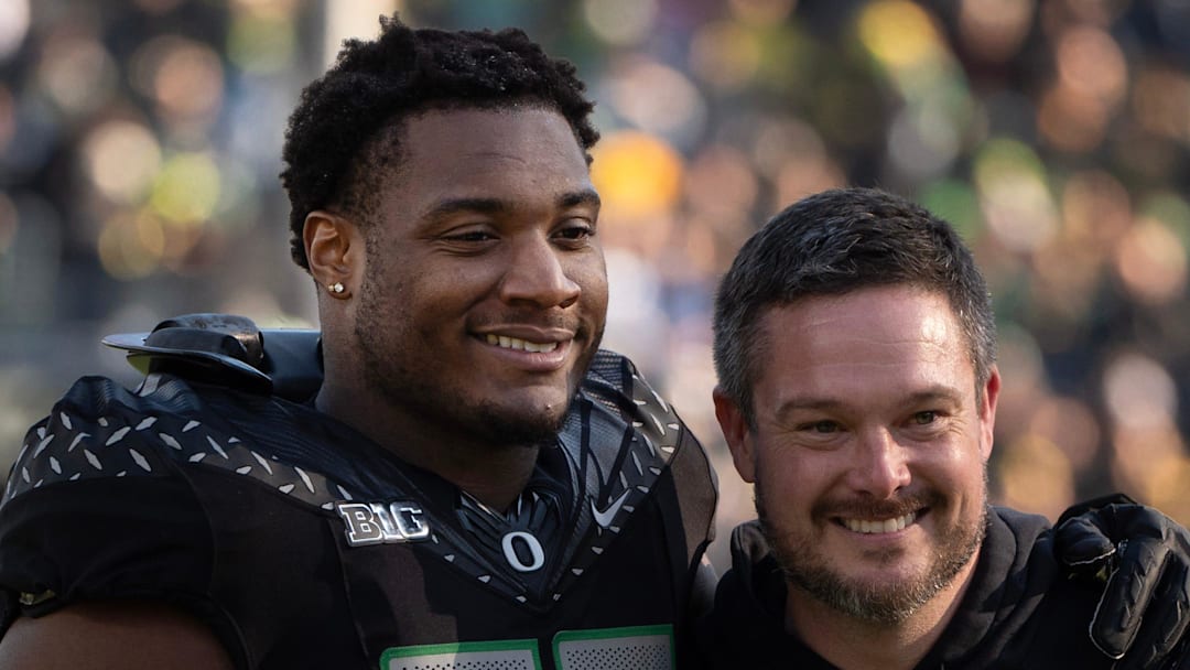 Oregon’s Isaiah World, left, takes a picture with coach Dan Lanning before the game against Southern California Nov. 22, 2025.