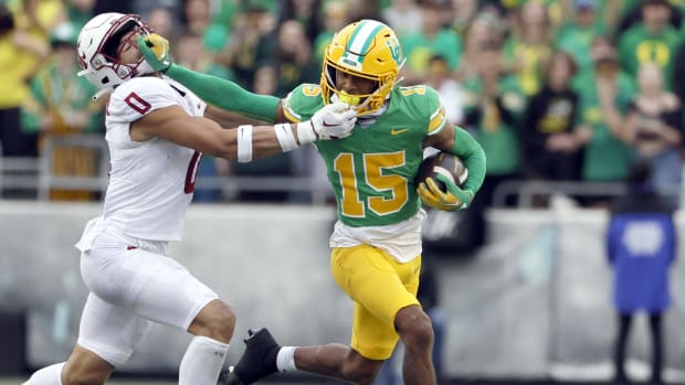 Oregon Ducks wide receiver Tez Johnson stiff arms a defender during a college football game.