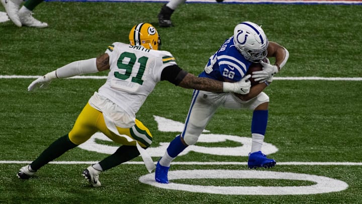 Indianapolis Colts running back Jonathan Taylor avoids Green Bay Packers defender Preston Smith in 2020.