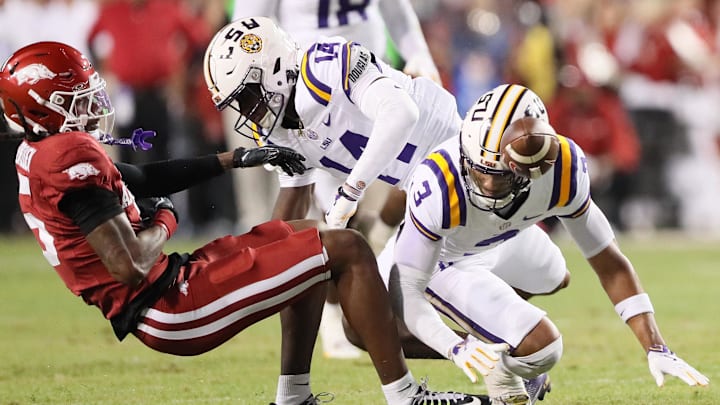 Oct 19, 2024; Fayetteville, Arkansas, USA; Arkansas Razorbacks wide receiver Tyrone Broken (5) attempts a catch as LSU Tigers cornerback Zy Alexander (14) and safety Sage Ryan (3) defend at Donald W. Reynolds Razorback Stadium. Mandatory Credit: Nelson Chenault-Imagn Images