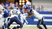 Sep 12, 2021; Indianapolis, Indiana, USA; Indianapolis Colts running back Jonathan Taylor (28) runs the ball while Seattle Seahawks defensive end Benson Mayowa (10) defends in the second half at Lucas Oil Stadium. Mandatory Credit: Trevor Ruszkowski-Imagn Images