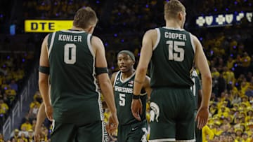 Feb 21, 2025; Ann Arbor, Michigan, USA; Michigan State Spartans guard Tre Holloman (5) talks with forward Jaxon Kohler (0) and center Carson Cooper (15) during the second half at Crisler Center. Mandatory Credit: Brian Bradshaw Sevald-Imagn Images