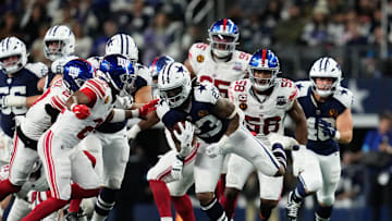 Nov 28, 2024; Arlington, Texas, USA;  Dallas Cowboys running back Rico Dowdle (23) runs the ball as New York Giants running back Eric Gray (20) defends during the second half at AT& T Stadium.  