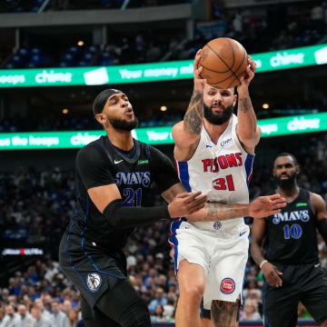 Apr 12, 2024; Dallas, Texas, USA; Detroit Pistons guard Evan Fournier (31)grabs a rebound between Dallas Mavericks center Daniel Gafford (21) and forward Olivier-Maxence Prosper (18) during the first half at American Airlines Center. Mandatory Credit: Chris Jones-USA TODAY Sports