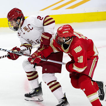 Apr 13, 2024; Saint Paul, Minnesota, USA; Boston College Eagles defenseman Eamon Powell (2) and Denver Pioneers forward Jared Wright (18) compete for the puck during the second period of the championship game of the 2024 Frozen Four college ice hockey tournament at Xcel Energy Center. Mandatory Credit: Matt Krohn-Imagn Images