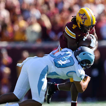 Sep 7, 2024; Minneapolis, Minnesota, USA; Minnesota Golden Gophers wide receiver Cristian Driver (4) runs after catching a pass as Rhode Island Rams defensive back Andre DePina-Gray (30) defends during the first half at Huntington Bank Stadium. Mandatory Credit: Matt Krohn-Imagn Images