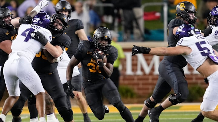 Nov 2, 2024; Waco, Texas, USA;  Baylor Bears running back Bryson Washington (30) runs the ball as TCU Horned Frogs linebacker Johnny Hodges (57) defends during the second half at McLane Stadium. Mandatory Credit: Chris Jones-Imagn Images