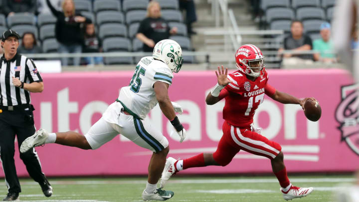 Dec 15, 2018; Orlando, FL, USA; Louisiana-Lafayette Ragin Cajuns quarterback Levi Lewis (17) runs out of the pocket as Tulane Green Wave linebacker Lawrence Graham (35) defends during the second half at Camping World Stadium. Mandatory Credit: 