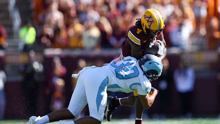 Sep 7, 2024; Minneapolis, Minnesota, USA; Minnesota Golden Gophers wide receiver Cristian Driver (4) runs after catching a pass as Rhode Island Rams defensive back Andre DePina-Gray (30) defends during the first half at Huntington Bank Stadium. Mandatory Credit: Matt Krohn-Imagn Images