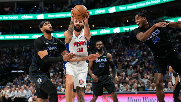 Apr 12, 2024; Dallas, Texas, USA; Detroit Pistons guard Evan Fournier (31)grabs a rebound between Dallas Mavericks center Daniel Gafford (21) and forward Olivier-Maxence Prosper (18) during the first half at American Airlines Center. Mandatory Credit: Chris Jones-USA TODAY Sports