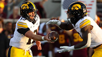 Sep 21, 2024; Minneapolis, Minnesota, USA; Iowa Hawkeyes quarterback Cade McNamara (12) hands the ball off to running back Kaleb Johnson (2) during the first half against the Minnesota Golden Gophers at Huntington Bank Stadium. Mandatory Credit: Matt Krohn-Imagn Images
