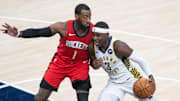 Jan 6, 2021; Indianapolis, Indiana, USA;  Indiana Pacers guard Aaron Holiday (3) dribbles the ball while Houston Rockets guard John Wall (1) defends in the second quarter at Bankers Life Fieldhouse. Mandatory Credit: Trevor Ruszkowski-Imagn Images