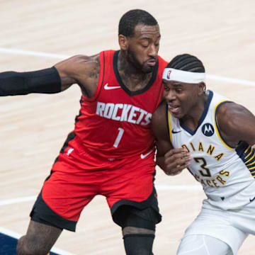 Jan 6, 2021; Indianapolis, Indiana, USA;  Indiana Pacers guard Aaron Holiday (3) dribbles the ball while Houston Rockets guard John Wall (1) defends in the second quarter at Bankers Life Fieldhouse. Mandatory Credit: Trevor Ruszkowski-Imagn Images