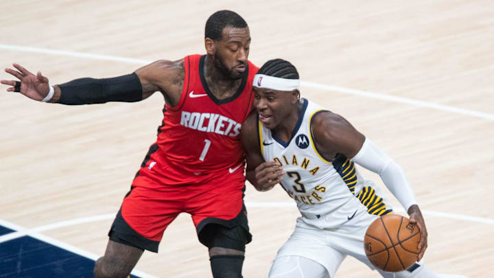 Jan 6, 2021; Indianapolis, Indiana, USA;  Indiana Pacers guard Aaron Holiday (3) dribbles the ball while Houston Rockets guard John Wall (1) defends in the second quarter at Bankers Life Fieldhouse. Mandatory Credit: Trevor Ruszkowski-Imagn Images