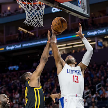 Feb 14, 2024; San Francisco, California, USA;  Golden State Warriors forward Jonathan Kuminga (00) defends against a shot by LA Clippers forward Paul George (13) during the second half at Chase Center. Mandatory Credit: John Hefti-Imagn Images