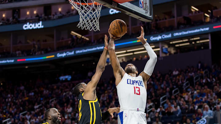 Feb 14, 2024; San Francisco, California, USA;  Golden State Warriors forward Jonathan Kuminga (00) defends against a shot by LA Clippers forward Paul George (13) during the second half at Chase Center. Mandatory Credit: John Hefti-Imagn Images